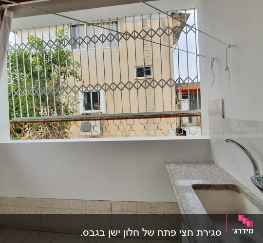 כיור גרניט עם ברז על רקע קיר גבס